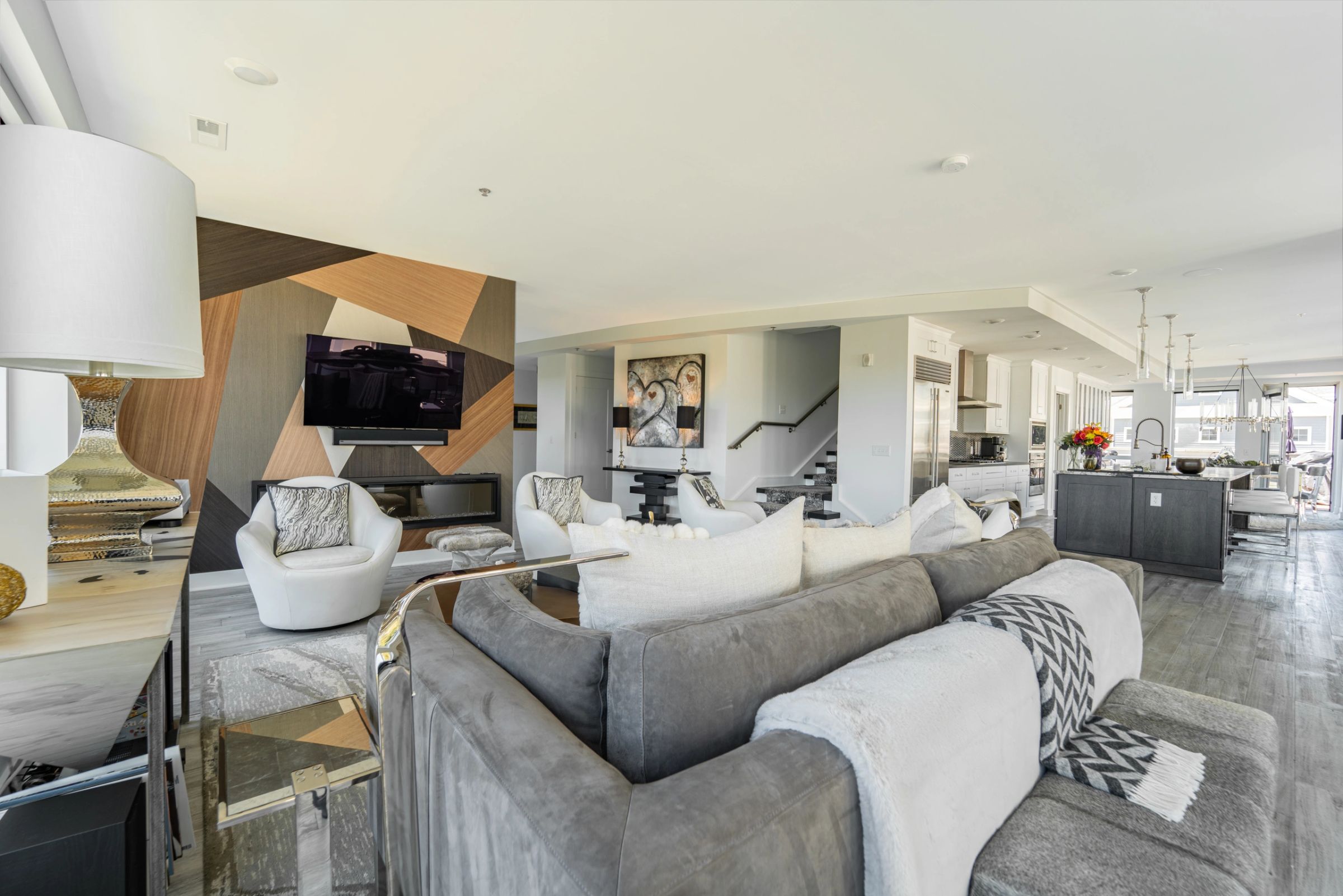 Open plan living room and kitchen designed by Daniel Home, with a sculptural inlaid feature wall and a linear fireplace
